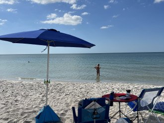 Naples beach with beach chairs and umbrella