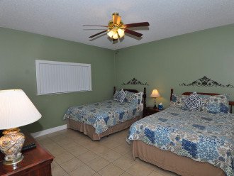 Spacious guest bedroom with 2 queen beds, TV, dresser, chest of drawers, closet