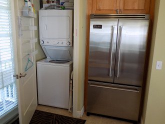 Fridge and Laundry closet with full size washer/dryer opposite kitchen