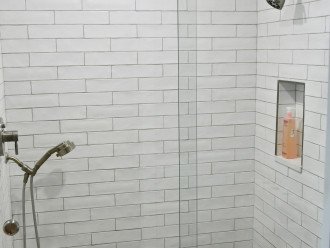 Master bathroom walk-in shower with fixed and handheld shower heads.
