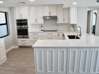 Custom cabinetry, soft-close drawers, Quartz countertops, touchless faucet.