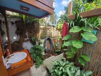 The outdoor shower room has a full rain shower, sink and toilet.