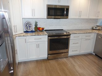 Stainless steel appliances and cermaic plank floors throughout