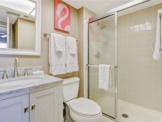 Guest bathroom has a large shower, closet, mirror and updated vanity