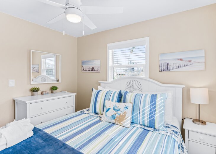 Drift off in your coastal-themed bedroom where ocean breezes from the ceiling fan and beach artwork create your perfect seaside retreat.
