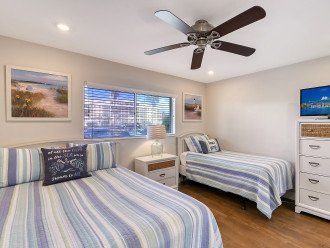 Guest bedroom queen bed & twin bed with TV and view of boat docks & parking