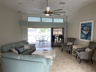 Living room with triple patio doors to lanai, pool and canal