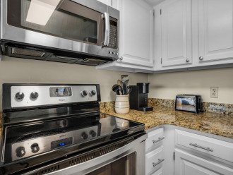 Fully stocked kitchen with stainless steel appliances and granite countertops.