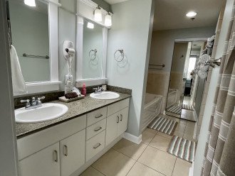 Master bath with double sink vanity has separate tub and shower