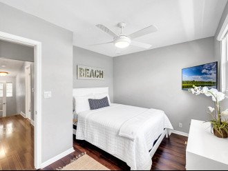 The third guest bedroom offers a queen-sized bed, a dresser and a smart T.V.