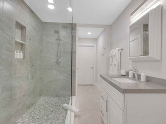The bathroom is located just across the second bedroom, featuring a walk-in shower.