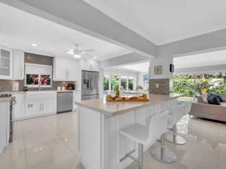 The large open kitchen is equipped with state of the art appliances for every gourmet chef. Extra counter space and a perfect view of the living room, dining room, and backyard oasis. Extra seating, featuring bar stools that seat 6.