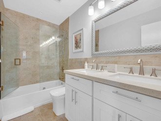 Both bedrooms two and three are conveniently located near the first full bathroom with double sinks, a shower, and bathtub.