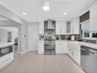 The large open kitchen is equipped with state of the art appliances for every gourmet chef. Extra counter space and a perfect view of the living room, dining room, and backyard oasis.