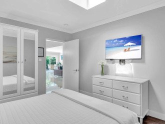 Bedroom five has a king bed, smart TV, and a skylight that invites guests to experience natural light and a relaxing ambiance.