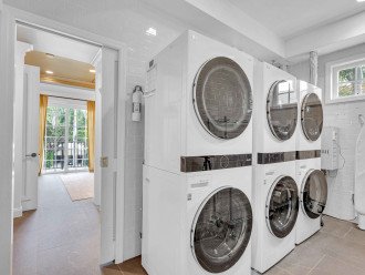 The laundry room is also located in the hallway, with not one, but THREE washer/dryer combos