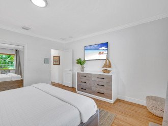 The master bedroom features a comfortable king-sized bed, a dresser, and a Smart TV.