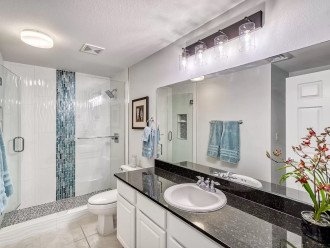 Guest bath has a walk in shower & vanity with granite top & storage space