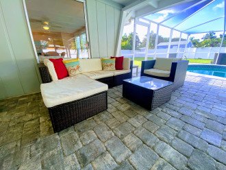 Shaded veranda has comfy sitting area and BBQ grill.