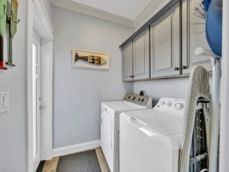Cheery Laundry Room on the First Level with Iron and Ironing Board