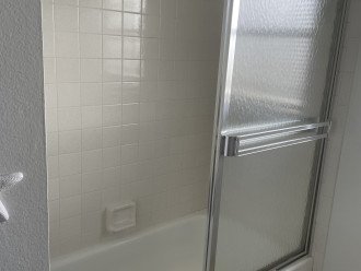 Shower and bathtub in second full bath. A closet that has beach and bath towels.