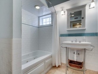 Next door is Bath 5 which also serves as the Hall Bath with Pedestal Sink and Subway Tile walls w/Glass inserts and Garden Tub/Shower Combo