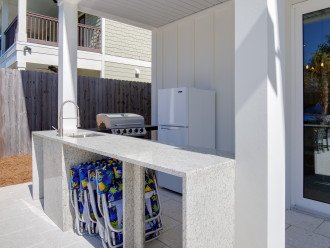 Fire up the grill. Outdoor kitchen with a fridge and a sink.