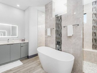 Master bathroom with soaker tub, walk through shower, and lighted anti-fog mirrors. Matching vanities on opposite walls.