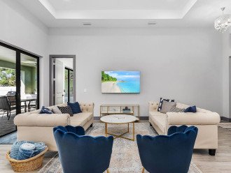 Modern beach chic decor greets you as you enter into the home via the front door (right). Relaxing in this living room gives you a great view of the pool and patio (left). 60" flat screen Roku smart TV is available for when you need to relax inside.