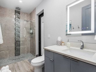 Second bathroom has a door out to the patio and heated salt water pool. Bathroom mirror is anti-fog, lighted, and contains a bluetooth speaker that you can be heard throughout the house.