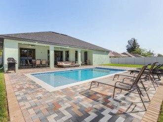Enjoy the private fenced-in backyard showcasing a heated, saltwater, south facing pool. Patio complete with lounge furniture, dining furniture, covered cooking and dining area, and Weber gas grill.