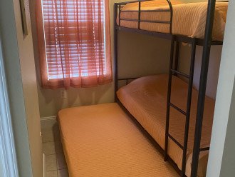 A semi-private bunk bed room with a window and storage space can sleep 3 people.