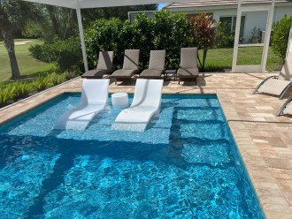 Six lounge chairs on patio and two in pool