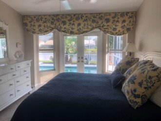 MASTER BEDROOM WITH FRENCH DOORS THAT OPEN TO THE LANAI AND POOL
