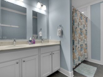Hallway bathroom being shared with BR2 and BR4, double sinks, hand soap, tissues