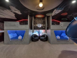 Front view of sleeping pods, TIE Fighter, and full-room murals