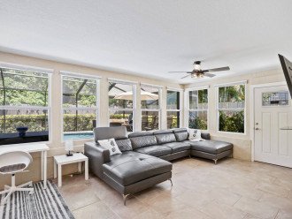 Gorgeous Florida Room with huge spacious couch that will fit a whole family for a movie night on a huge 65" smart TV with Netflix, Amazon and Hulu.