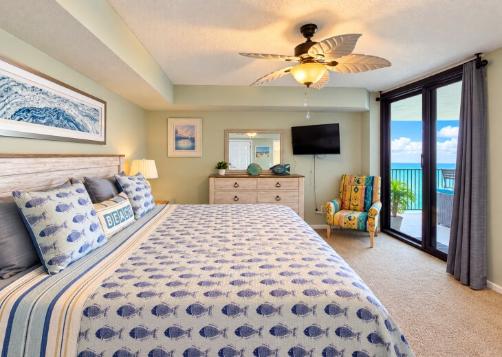 Comfortable king bed with balcony access, Gulf views, and a TV.
