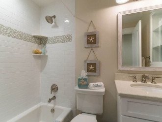 Guest Bathroom has Shower/Tub combination, Single Sink and Cabinet for Towels.