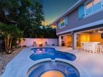 Beautifully lit backyard with solar torches, pool lighting, ambient lighting