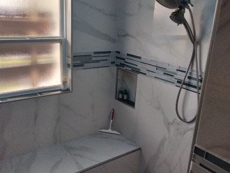 Remodeled hall bathroom shower with bench