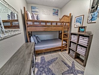 Bunkroom has a set of twin beds with a smart tv