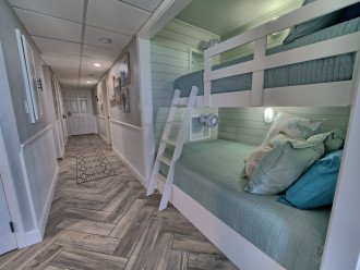 Built in bunks in the hallway has a full size bed on the bottom and a twin on the top with outlets for devices, fans and lighting