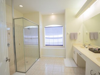 Master Bath with dual sinks, large walk in shower, and a private toilet area