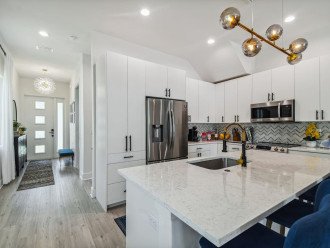 Contemporary design full kitchen, quartz countertop, contemporary barstools, tons of cabinet space, stainless steel appliances, and coffee/snack bar.
