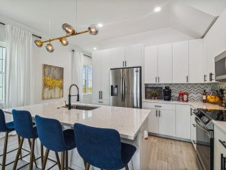 Contemporary design full kitchen, quartz countertop, contemporary barstools, tons of cabinet space, and stainless steel appliances. Includes coffee and snack bar.