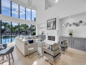 The living room offers a view of the waterfront and the heated swimming pool.