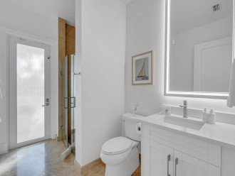 The guest bathroom features a walk-in shower and access to the backyard pool area.