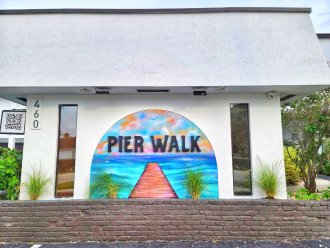 Our Pier Walk signage outside w/ our custom mural painted by local artist MSG Concepts and designed 100% by your host Danielle. Meet your guests easily at the Pier Walk sign on South Ocean Dr!