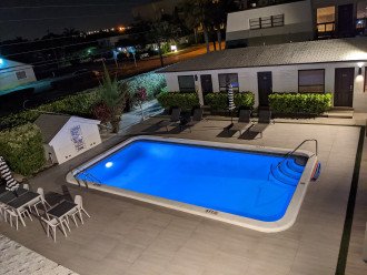 Wide view of pool deck at night from the second floor.